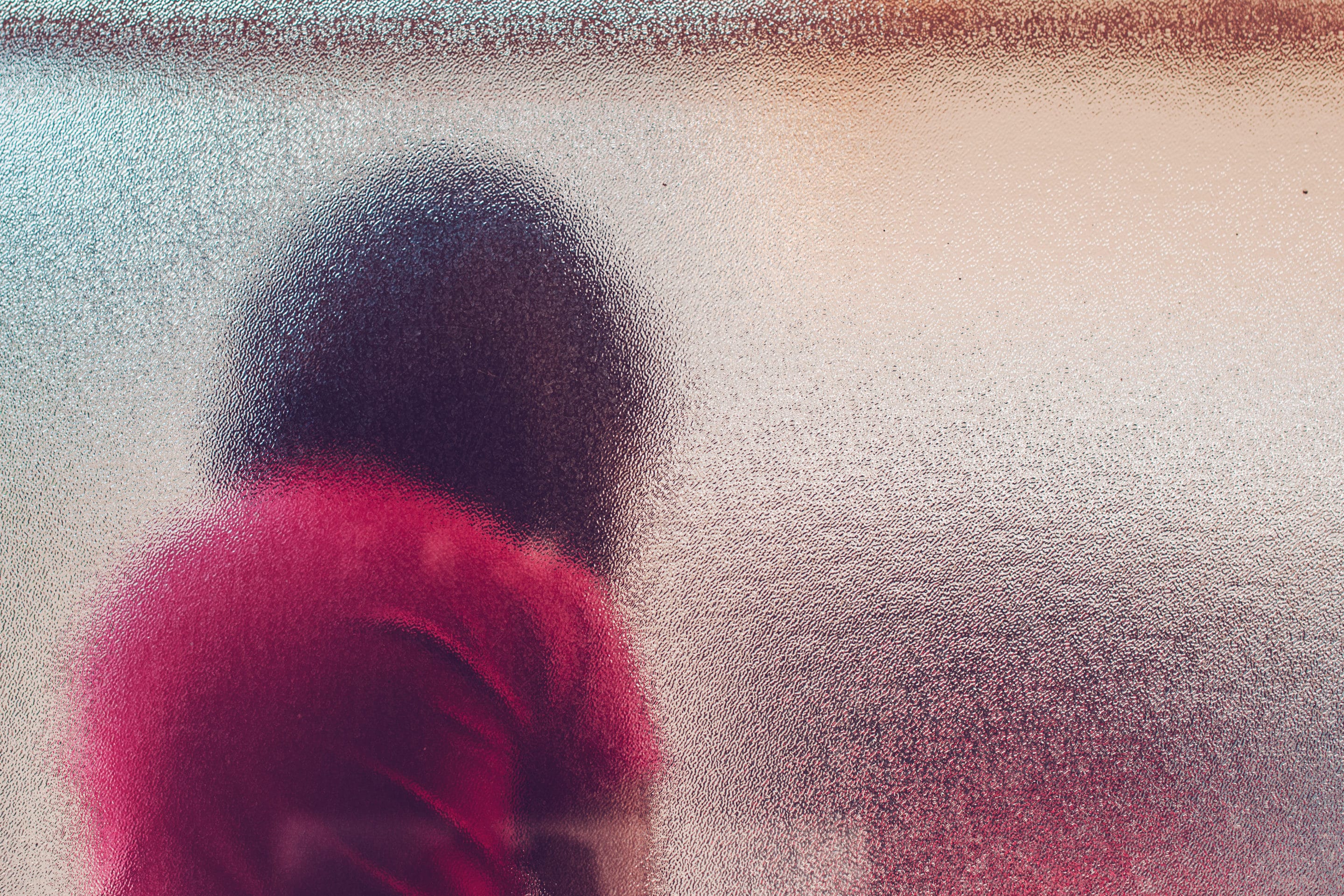 Silhouette of unrecognizable sad autistic girl behind stained gl